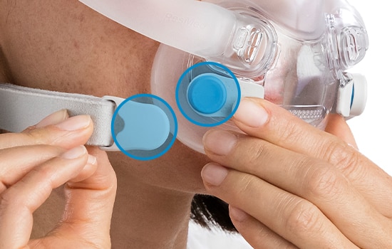 Un primer plano de los clips magnéticos de una mascarilla de ResMed mientras se ajustan, con los imanes en círculos